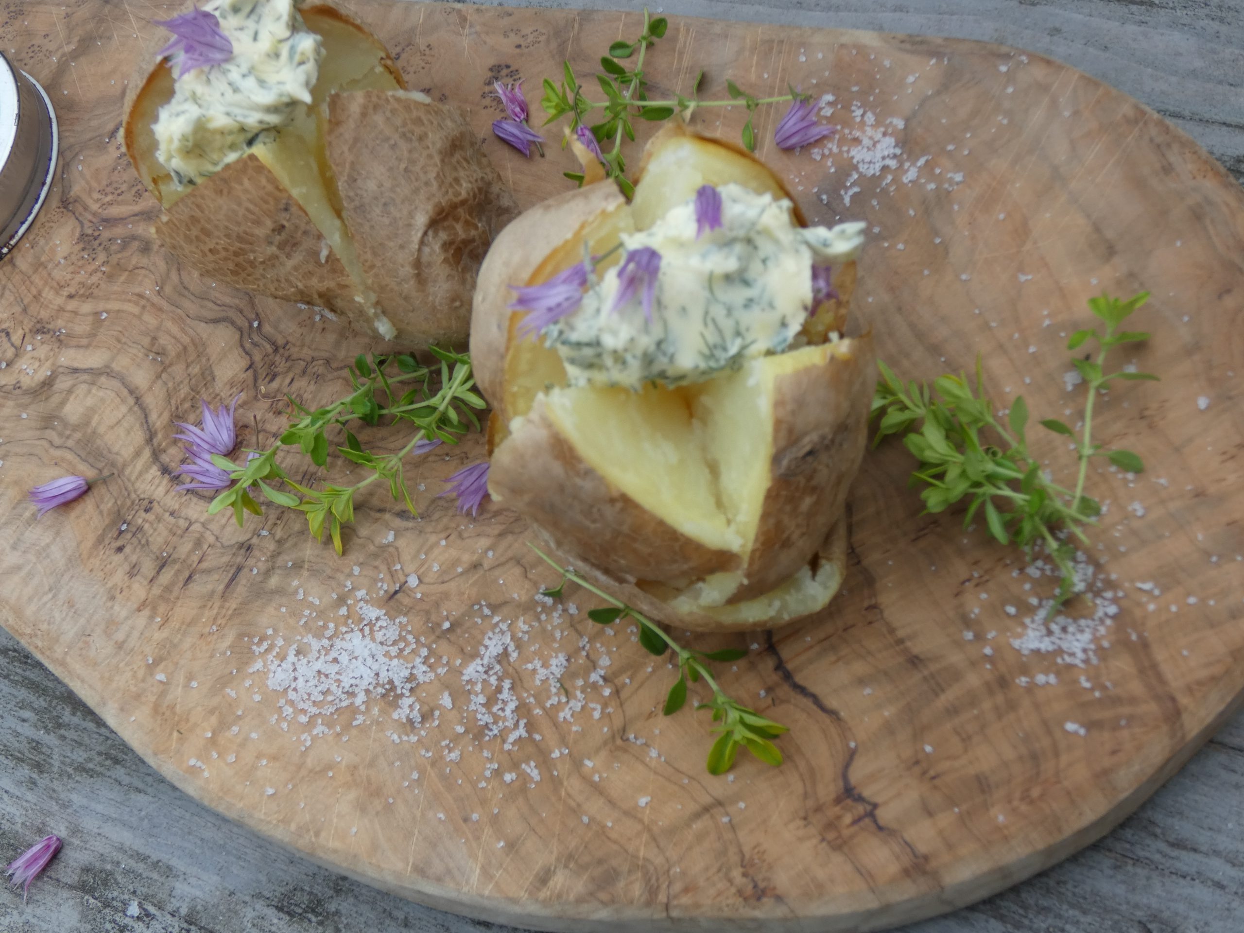 baked potatoes with butter on a wooden board
